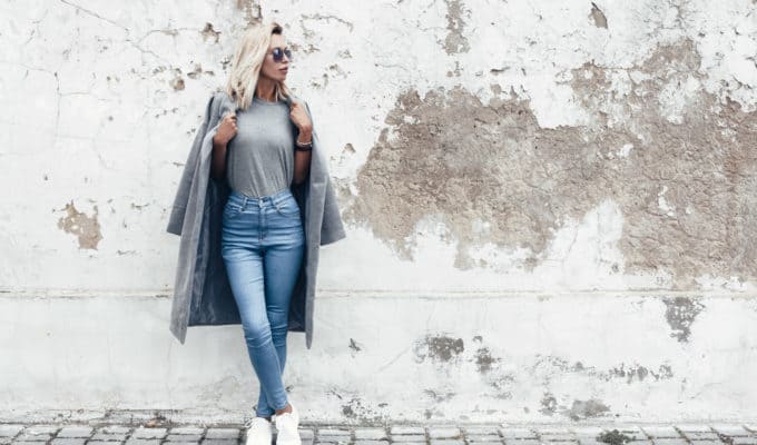 Model post in T-Shirt an Mauer