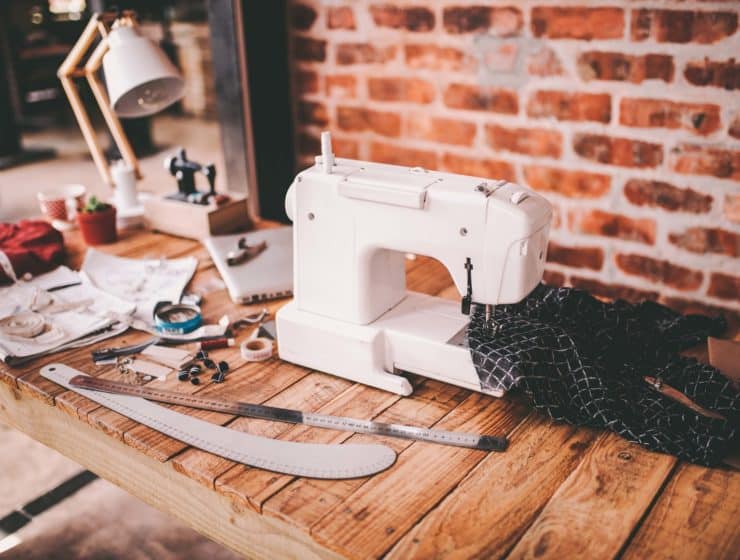 Nähen für Anfänger - ein Arbeitstisch mit Nähmaschine und Nähutensilien